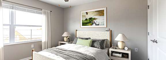 A bedroom with a large bed, a small table with a lamp, and a window with curtains.