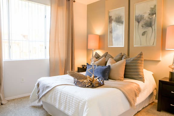 a bedroom with a bed with a white comforter and pillows