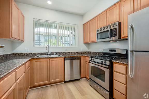 A kitchen with wooden cabinets and stainless steel appliances.