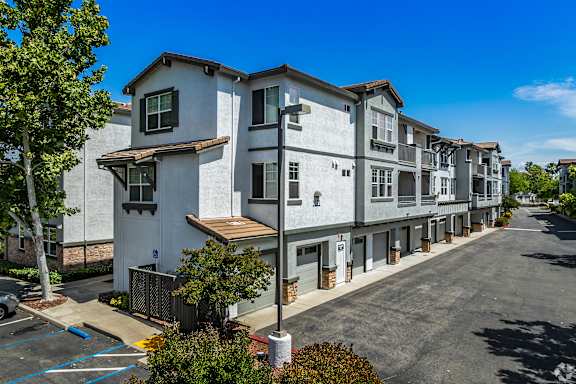 A row of modern townhouses with a clear blue sky above.