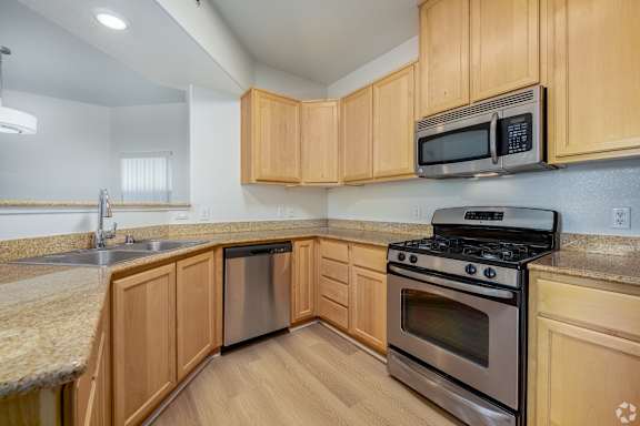 A kitchen with wooden cabinets and a black stove top oven.