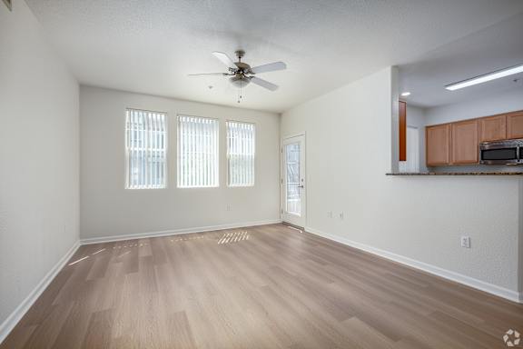 A room with a ceiling fan and wooden flooring.