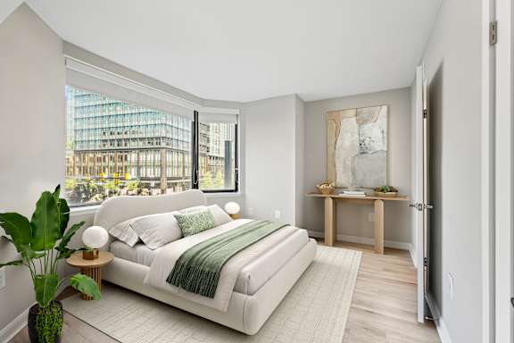 a bedroom with a white bed and a large window