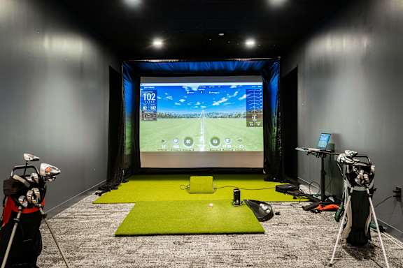 a training room with a screen in the center of the room and two cameras on