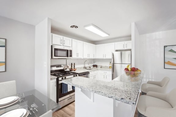 a kitchen with white cabinets and a granite counter top