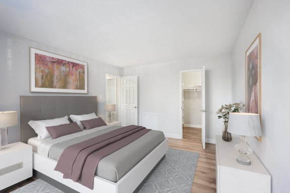 a bedroom with white walls and a bed with purple pillows