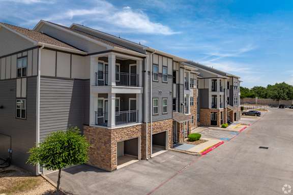 A row of modern townhouses with a clear blue sky above.