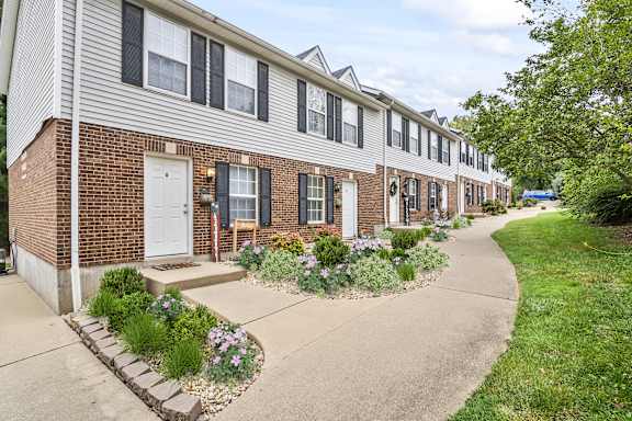 A row of houses with a sidewalk in front.