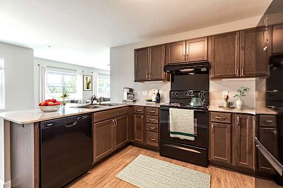 Modern kitchen with dark wood cabinets and black appliances at Collingwood Green Living Apartments, Toledo, OH 43604