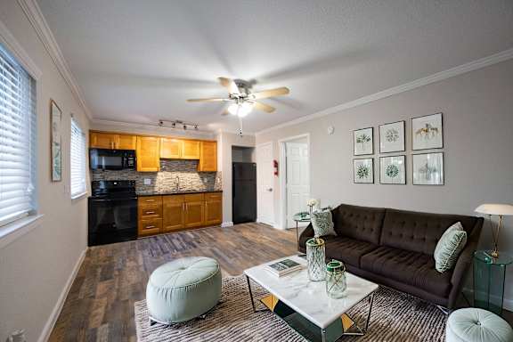 a living room with a couch and a coffee table and a kitchen