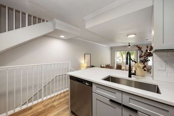 A modern kitchen with a stainless steel dishwasher and a white countertop.