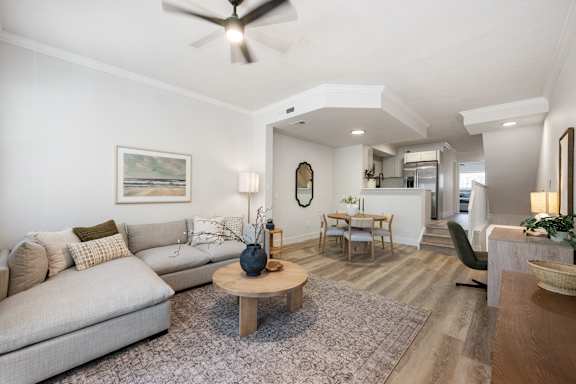 A living room with a grey sofa, a wooden coffee table, and a painting on the wall.
