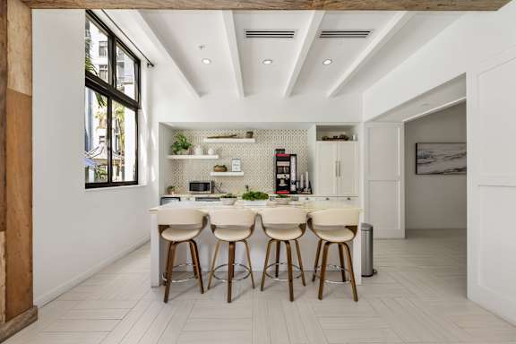 A modern kitchen with white cabinets and a large island.