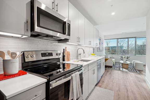 a kitchen with grey cabinets and stainless steel appliances and a microwave