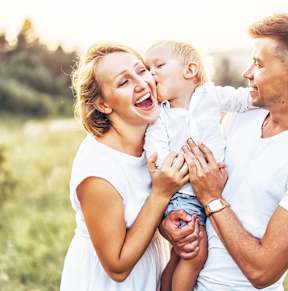 A family of three is enjoying a sunny day outdoors.