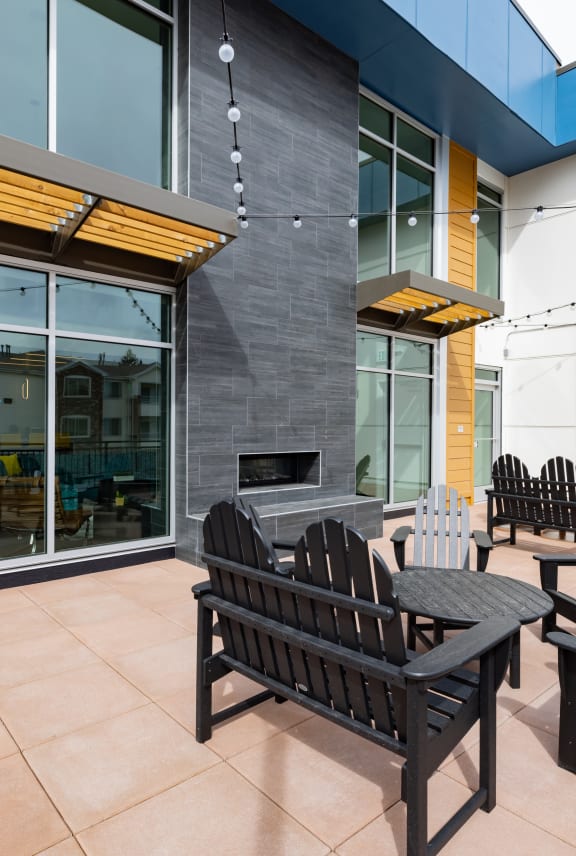 a patio with wooden chairs and a fire pit
