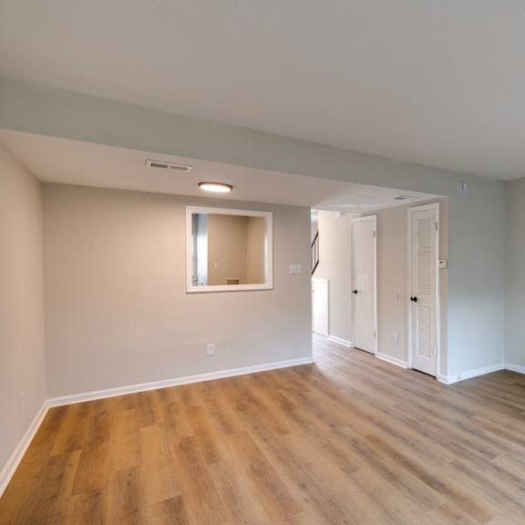 A room with wooden flooring and white walls. at Savan Pointe, Savannah