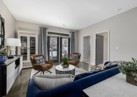 a living room with a blue couch and two chairs