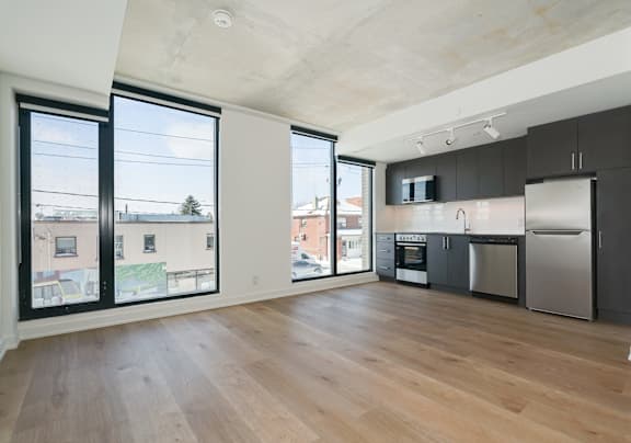 A kitchen with a refrigerator, oven, and microwave.