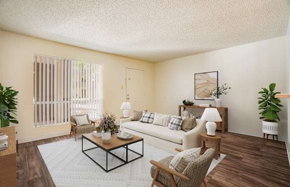 A living room with a white couch, a coffee table, and a potted plant.