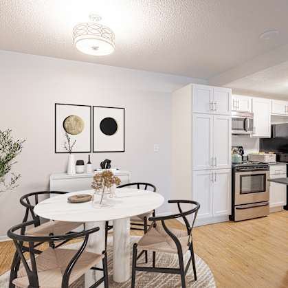 A modern kitchen with a dining table set for two.