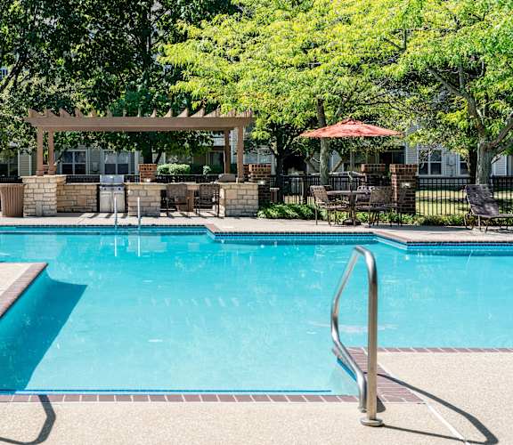A pool with a diving board and a gazebo in the background.