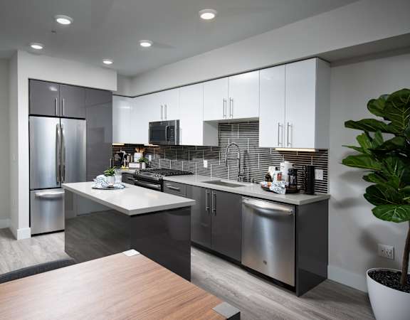 a kitchen with white cabinets and stainless steel appliances