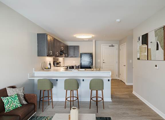 A kitchen with a bar and stools.