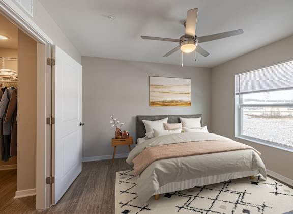 A bedroom with a large bed and a ceiling fan.