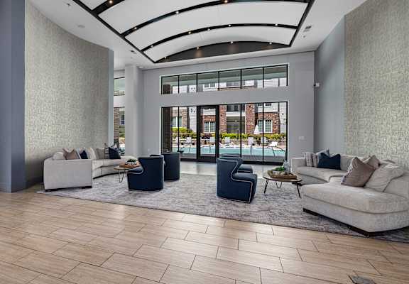 a living room with couches and chairs in front of a glass door