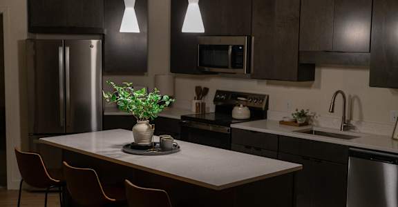 A kitchen with a table and chairs and a refrigerator.