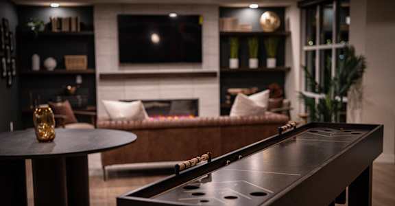 A pool table in a room with a fireplace and a couch.