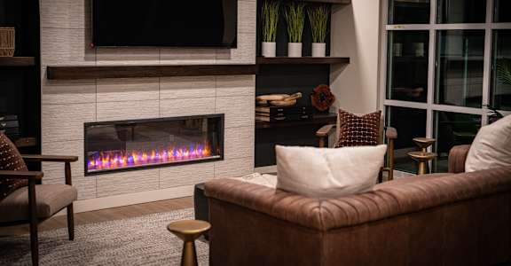 A modern living room with a fireplace and a flat screen TV mounted above it.