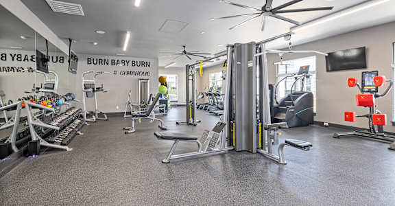 a gym with weights and cardio equipment at the apartments