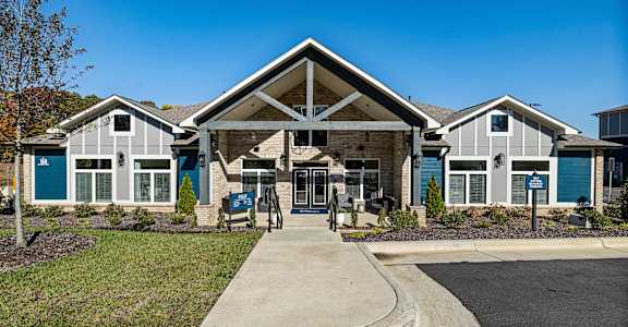 the front of a house with blue doors and a sidewalk in front of it