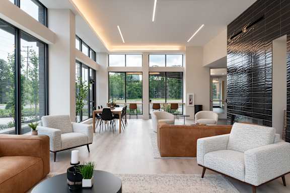 A modern living room with white furniture and a large window.