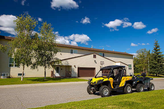 A black and yellow ATV is parked in front of a house.