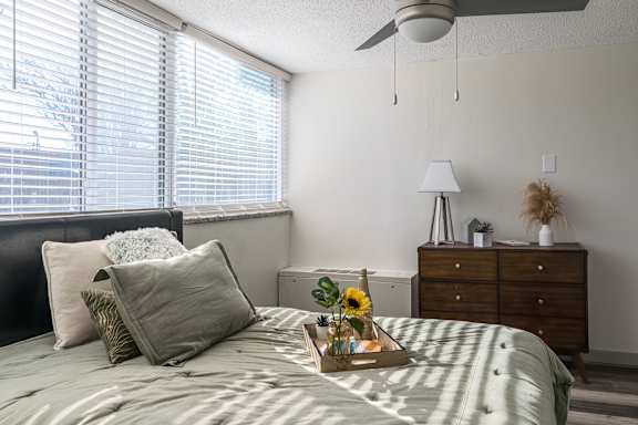 a bedroom with a bed with pillows and a tray on it