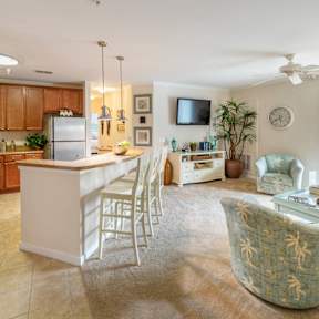 A kitchen with a white island and a dining table with chairs.