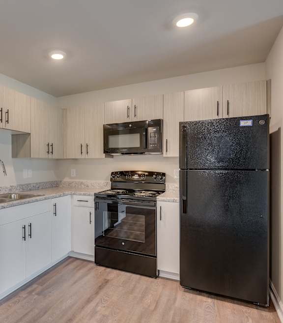 a wine cellar with white cabinets and wooden floors and a machine in the middle