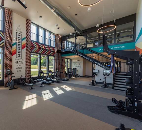 a photo of a gym with cardio equipment and a spiral staircase