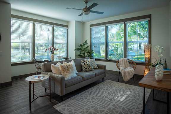 A modern living room with a grey couch and a cowhide rug.