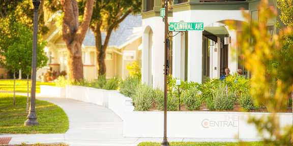 A row of houses with a sidewalk in front.