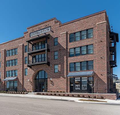 a large brick building with a sign that says university on top of it at Livingston Flats Apartments, Chesterfield, VA, 23832