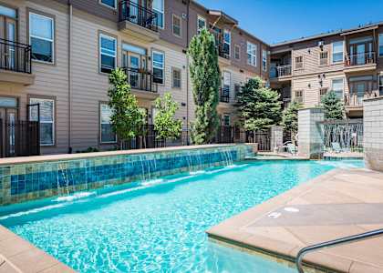 a swimming pool with an apartment building in the background