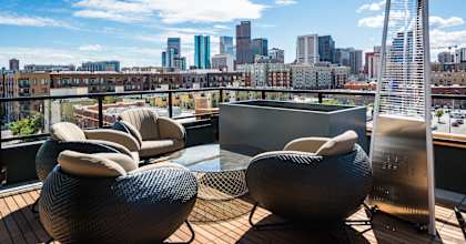 A balcony with chairs and a city skyline in the background.