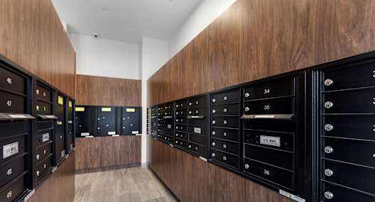A long hallway with mailboxes on the wall.