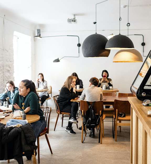 people sitting at tables in a restaurant