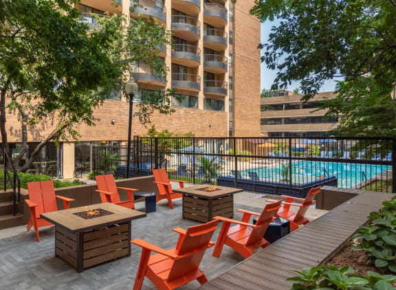 a patio with tables and chairs near a swimming pool