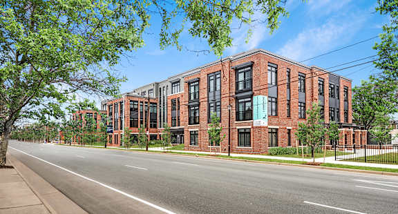A street view of a red brick building with a clear blue sky above.